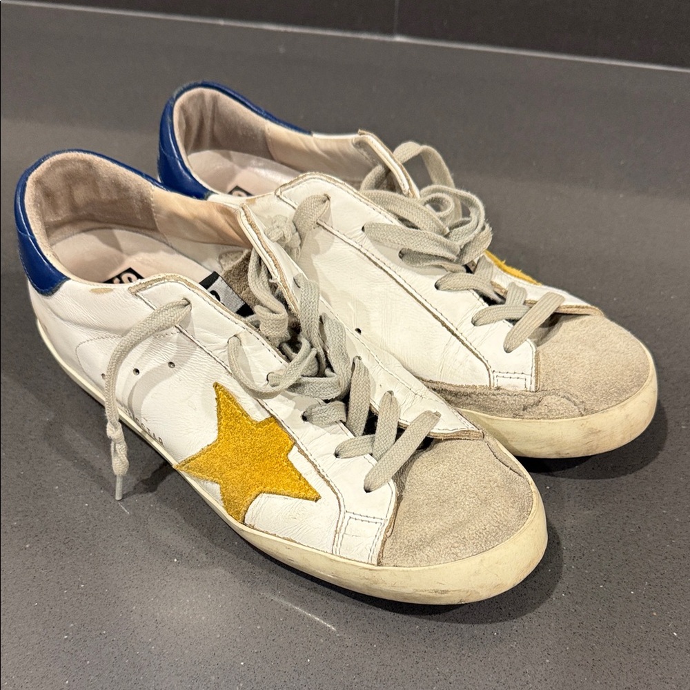 GOLDEN GOOSE SUPERSTAR White Sneakers with Yellow Star and Blue Heel.